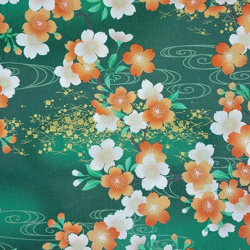 Green Japanese fabric with white, ornage and gold cherry blossom patterns